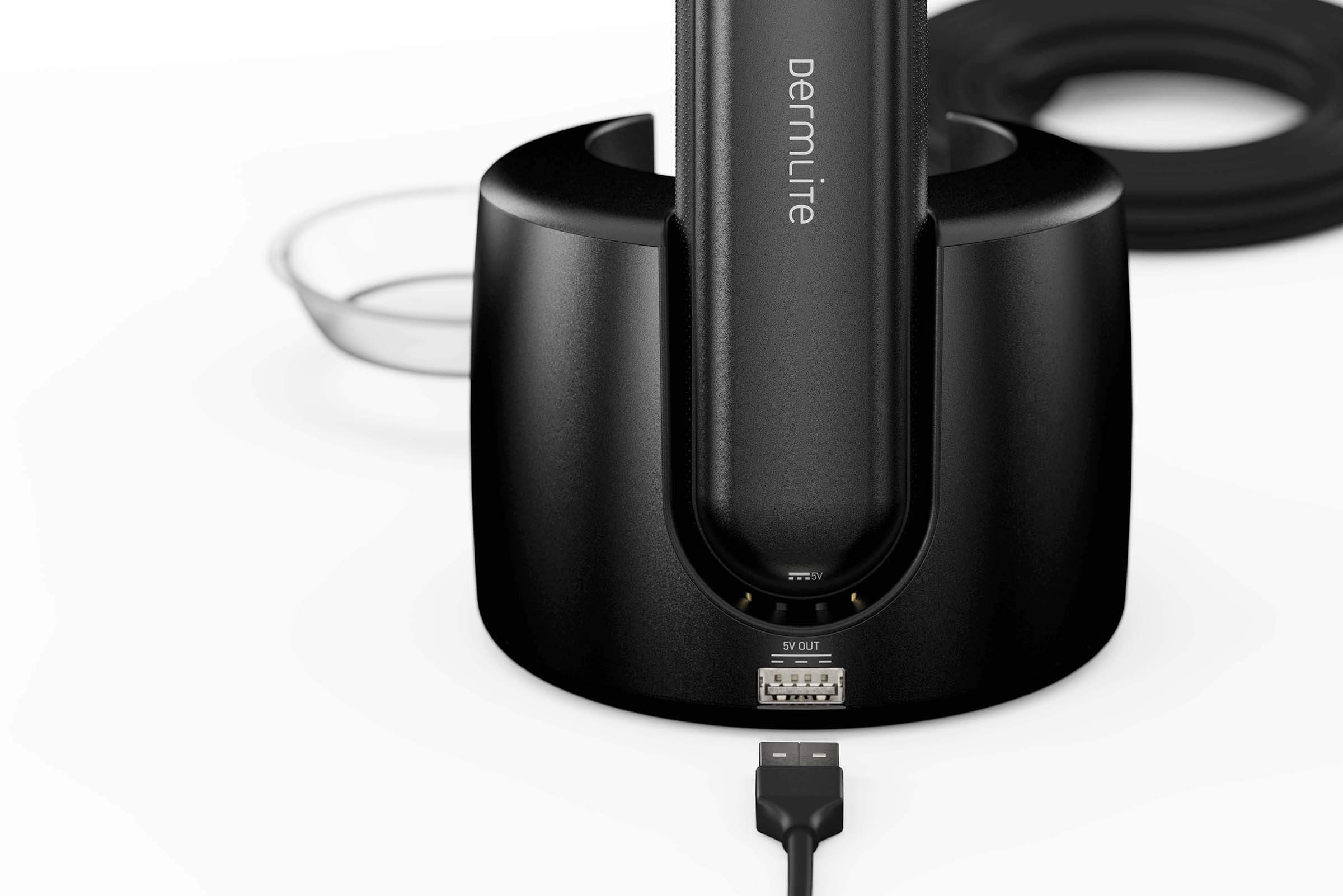 DermLite DL5 dermatoscope USB cable being plugged into the charging base.