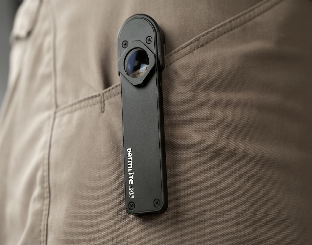 DermLite DL1 dermatoscope fixed to trouser pocket.