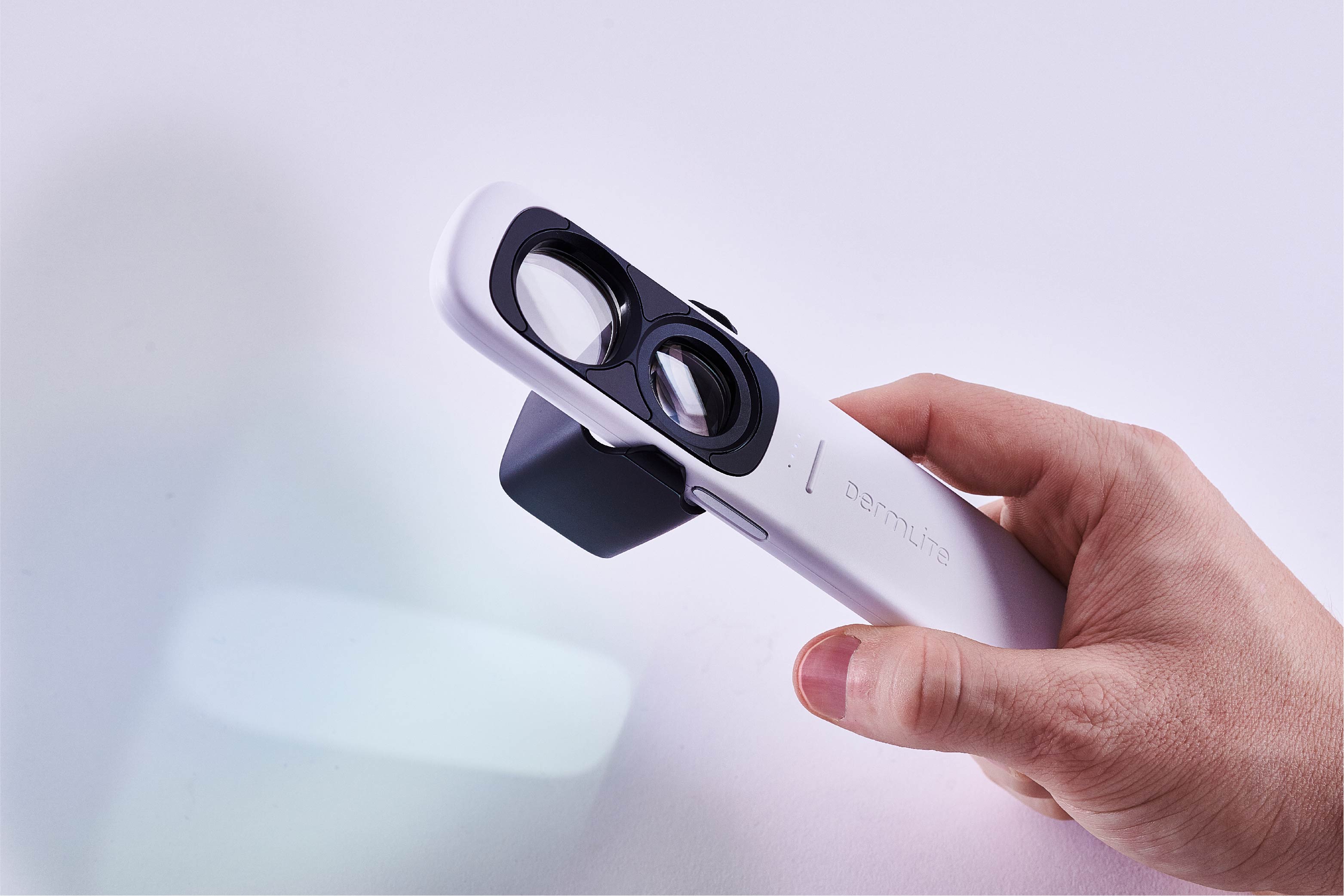 DermLite GL dermatoscope held by hand.