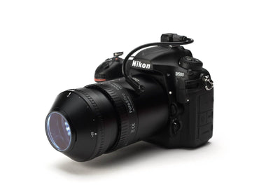 A Nikon D500 DSLR camera body with a zoom lens, shown from a three-quarters angle on a clean white background.